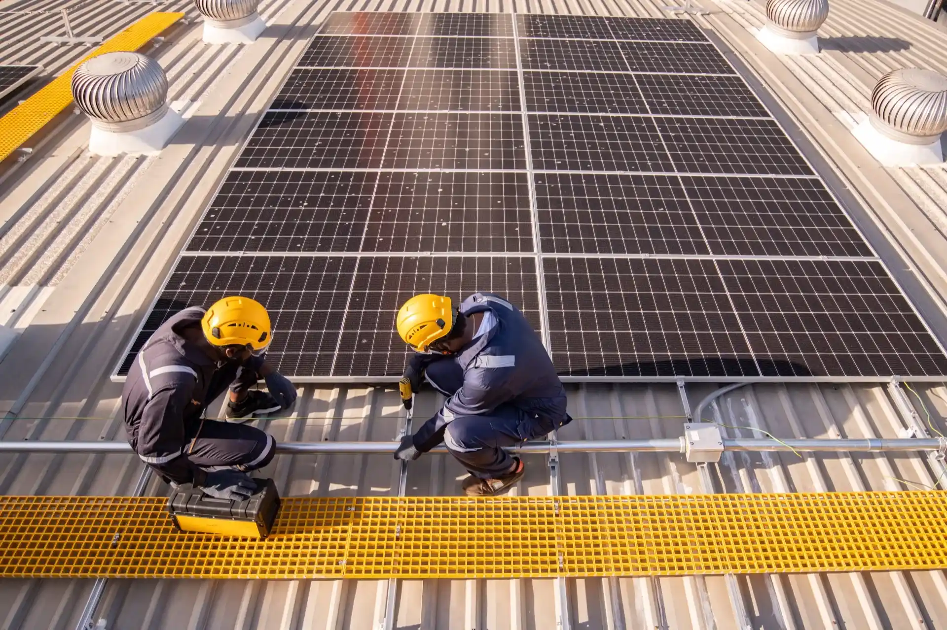 Engineers inspecting solar panels on a rooftop installation